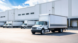 A series of box trucks backed up to loading docks.